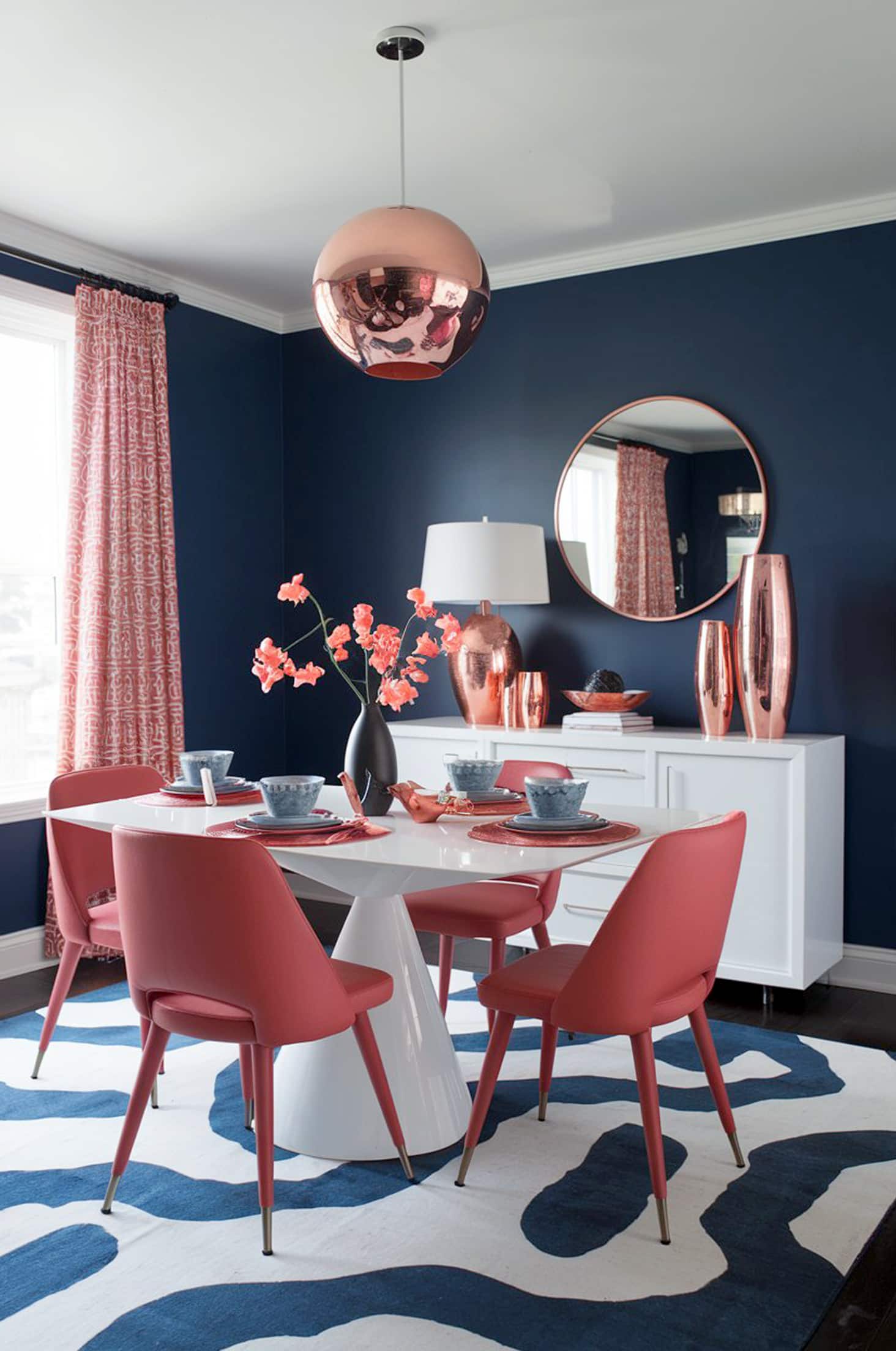 Chic coral & blue dining room with white table and copper accents