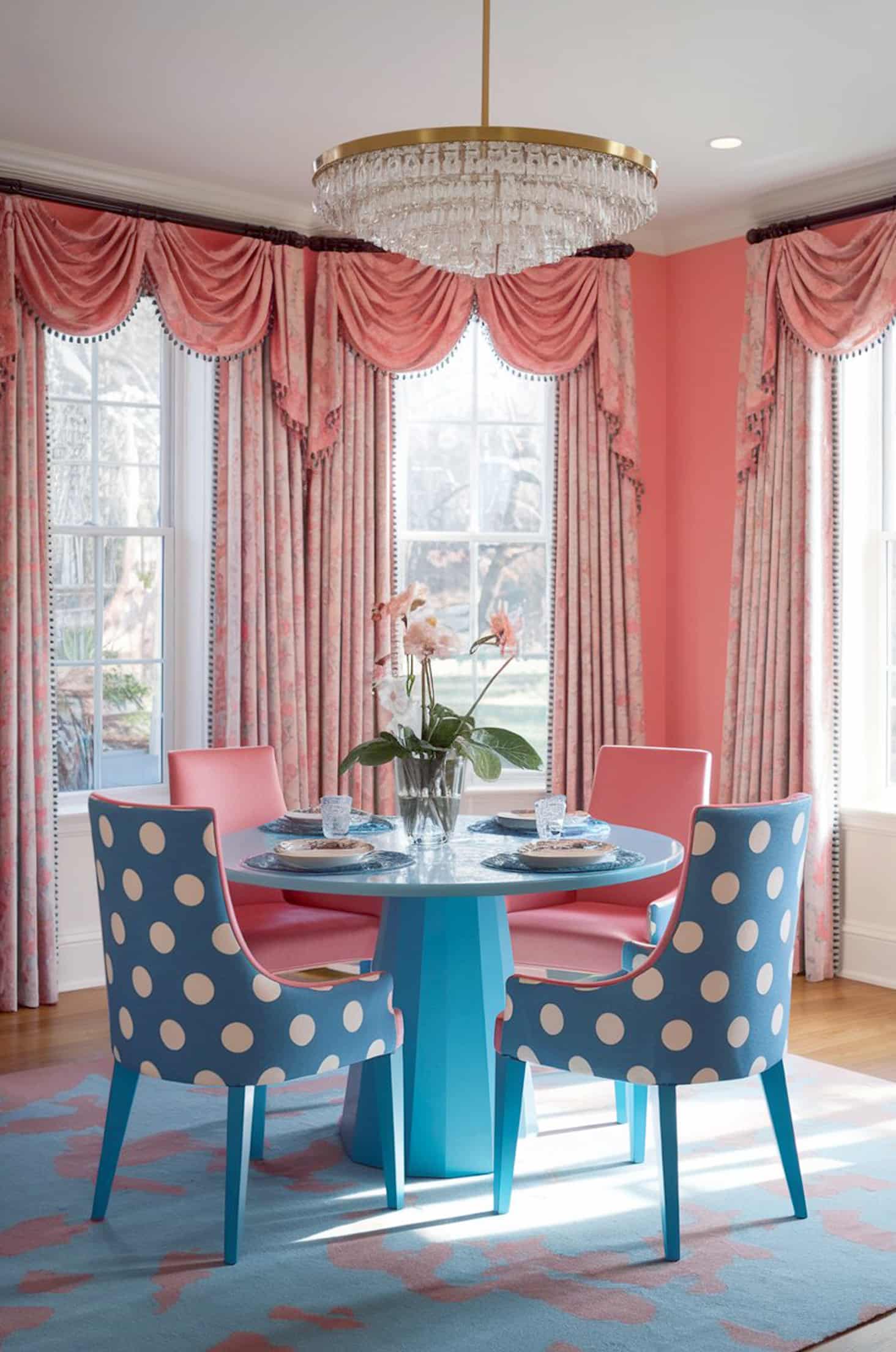 Playful coral & blue dining room with polka dot tables and elegant drapery