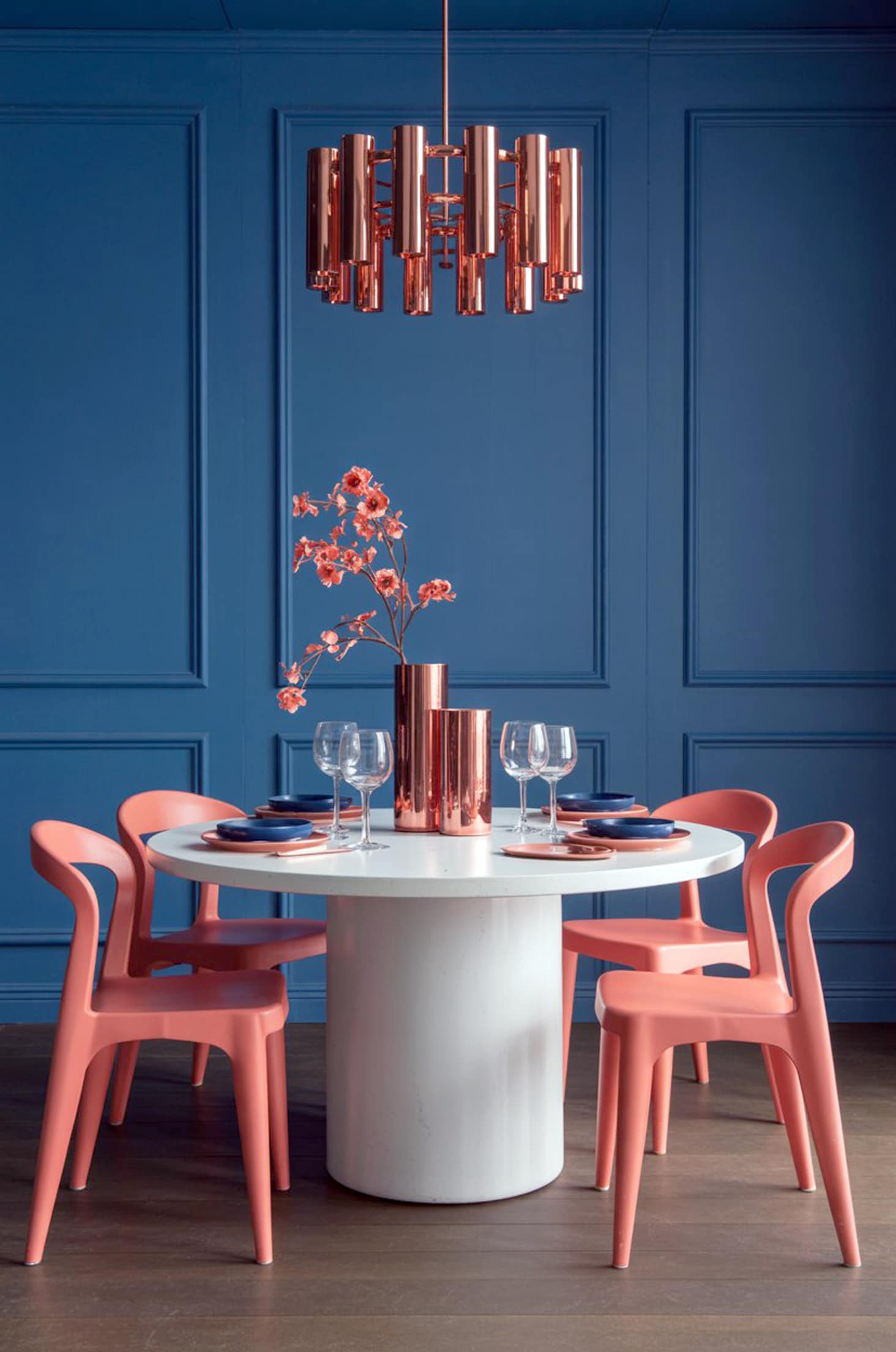 Sophisticated coral & blue dining room with white table and copper touches