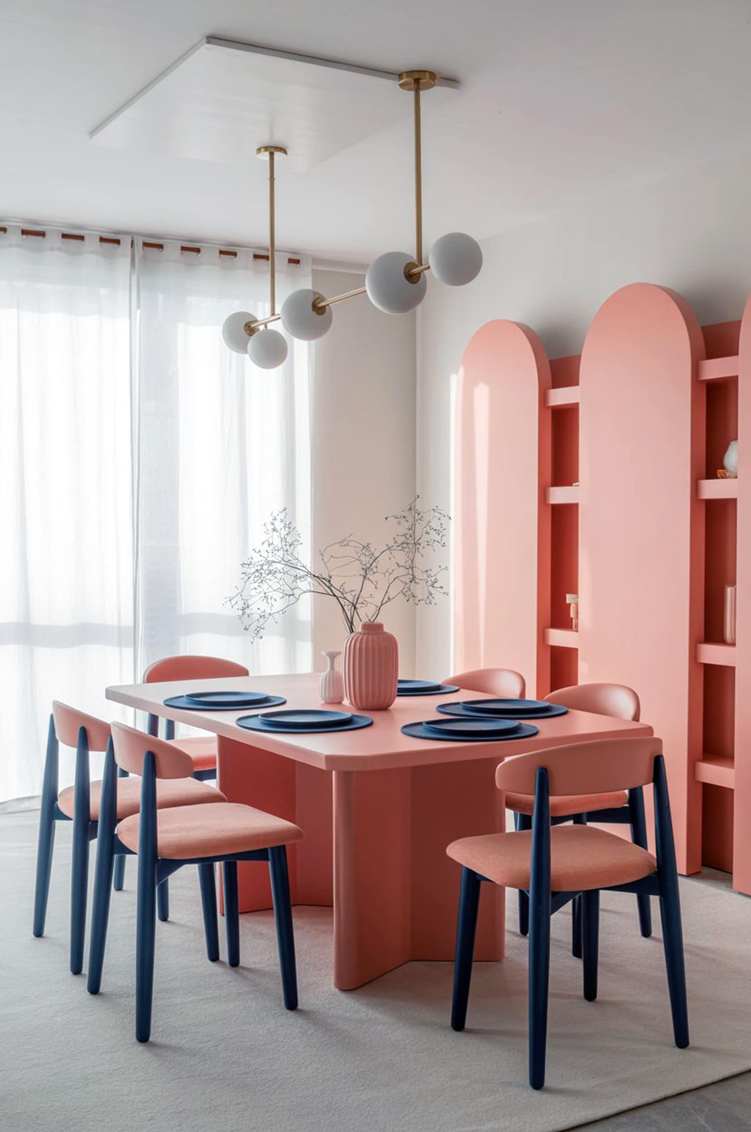 Stylish coral & navy dining room with pastel furniture and blue accents